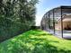 Manicured backyard featuring a screened pool enclosure, lush lawn, and tall hedges for privacy at 812 Eagle Claw Ct, Lake Mary, FL 32746