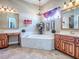 Elegant bathroom with a soaking tub, dual vanities, and a decorative chandelier at 812 Eagle Claw Ct, Lake Mary, FL 32746