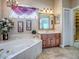 Bright bathroom featuring a soaking tub, vanity with storage, and a window with decorative accents at 812 Eagle Claw Ct, Lake Mary, FL 32746