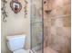 Bathroom featuring a toilet and glass shower with travertine-style tiling at 812 Eagle Claw Ct, Lake Mary, FL 32746