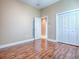 Bedroom featuring wood-look flooring, neutral paint, closet, and an open door that leads to another room at 812 Eagle Claw Ct, Lake Mary, FL 32746
