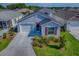 Aerial view of a single-Gathering home with a well-kept lawn and landscaping in a suburban neighborhood at 865 Conroe St, The Villages, FL 34762