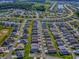 Overhead view of a residential area including several houses near community amenities like a pool and tennis courts at 865 Conroe St, The Villages, FL 34762