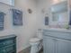 Clean bathroom with gray vanity, decorative seashell accents and coordinated blue towels for a beachy feel at 865 Conroe St, The Villages, FL 34762