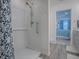 Beautifully tiled walk-in shower with modern fixtures and neutral gray walls and wood look flooring at 865 Conroe St, The Villages, FL 34762