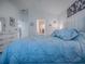 Bright bedroom featuring a comfortable blue bed, ensuite bathroom, and walk-in closet at 865 Conroe St, The Villages, FL 34762
