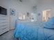 Bright bedroom featuring a comfortable blue bed, matching dresser and soft lighting at 865 Conroe St, The Villages, FL 34762