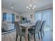 Dining area featuring modern chandelier, patio access and a cozy sitting area in a naturally lit open-concept space at 865 Conroe St, The Villages, FL 34762