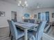 Dining area with a table and six chairs, chandelier, natural light from a window and views to the living area at 865 Conroe St, The Villages, FL 34762