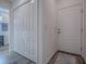 Bright entryway with white door, wood-look floors, bi-fold closet and a gray rug; leads to the bedroom at 865 Conroe St, The Villages, FL 34762