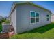 Exterior view of home with vinyl siding, green grass, a modern A/C unit, and double pane windows at 865 Conroe St, The Villages, FL 34762