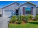Charming home featuring a well-maintained lawn and landscaping, a front porch, and a two-car garage at 865 Conroe St, The Villages, FL 34762