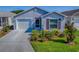 Beautiful home with a well-manicured lawn, a two-car garage, and classic architectural details at 865 Conroe St, The Villages, FL 34762
