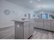 Open kitchen area highlighting the gray island, cabinets, and view into the living space of the home at 865 Conroe St, The Villages, FL 34762