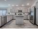 Spacious kitchen showcasing stainless steel appliances, ample gray cabinetry, and a functional center island at 865 Conroe St, The Villages, FL 34762