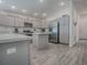 Contemporary kitchen featuring stainless steel appliances, gray cabinetry, a center island, and stylish flooring at 865 Conroe St, The Villages, FL 34762