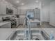 Bright kitchen with stainless appliances, grey cabinets, kitchen island and undermounted stainless steel sink at 865 Conroe St, The Villages, FL 34762