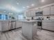 Modern kitchen with stainless steel appliances, gray cabinets, a kitchen island, and wood-look flooring at 865 Conroe St, The Villages, FL 34762