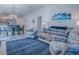 Bright and airy living room with comfortable seating, a blue rug, and an open layout connecting to dining and kitchen at 865 Conroe St, The Villages, FL 34762
