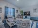 Living room featuring bright blue accents, comfortable seating arrangements, and a flat-screen TV for entertainment at 865 Conroe St, The Villages, FL 34762