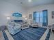 Comfortable living room with nautical-themed chairs, light grey sofa, stylish coffee table, and a vibrant blue rug at 865 Conroe St, The Villages, FL 34762