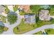 Aerial view of a gray roofed home with a long driveway surrounded by lush landscaping in a peaceful neighborhood at 8980 Se 176Th Limerick Ln, The Villages, FL 32162