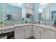 Bright bathroom featuring dual sinks, white cabinets, and plenty of counter space and natural light at 8980 Se 176Th Limerick Ln, The Villages, FL 32162
