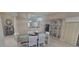 Dining room with white wicker chairs, display cabinet, and modern lighting at 8980 Se 176Th Limerick Ln, The Villages, FL 32162