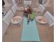 Dining table is elegantly set with plates, glasses and a stylish runner at 8980 Se 176Th Limerick Ln, The Villages, FL 32162