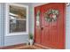 Stylish front door with sidelight, brick entryway, and coastal-themed wreath at 8980 Se 176Th Limerick Ln, The Villages, FL 32162
