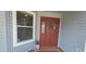 Charming entryway with a red front door, brick steps and coastal wreath at 8980 Se 176Th Limerick Ln, The Villages, FL 32162