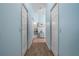 Hallway with wood-look floors, light blue walls, and doors leading to various rooms at 8980 Se 176Th Limerick Ln, The Villages, FL 32162