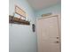 Hallway with a decorative hook rack and white door, painted in a calming blue at 8980 Se 176Th Limerick Ln, The Villages, FL 32162