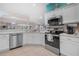 Well-lit kitchen with stainless steel appliances and breakfast bar overlooking the living area at 8980 Se 176Th Limerick Ln, The Villages, FL 32162