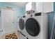 Modern laundry room featuring a side-by-side washer and dryer, and ample cabinet space at 8980 Se 176Th Limerick Ln, The Villages, FL 32162