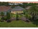 Back exterior view of home with a lovely lawn, landscaping, and neutral toned exterior at 9307 San Jose Blvd, Howey In The Hills, FL 34737