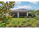 Backyard view featuring lush landscaping, well-maintained lawn and a peek at the screened-in porch at 9307 San Jose Blvd, Howey In The Hills, FL 34737