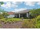 Landscaped backyard with manicured lawn, garden beds and screened-in outdoor living space at 9307 San Jose Blvd, Howey In The Hills, FL 34737
