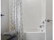 Bright tub and shower featuring white subway tiles and a neutral shower curtain at 9307 San Jose Blvd, Howey In The Hills, FL 34737