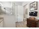 Bright bathroom area showcases a glass shower, closet with open doors, vanity and stylish wall decor at 9307 San Jose Blvd, Howey In The Hills, FL 34737