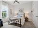 Bright bedroom with a large window, black bed frame, and neutral finishes at 9307 San Jose Blvd, Howey In The Hills, FL 34737