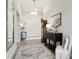 Bright foyer featuring neutral walls, white trim, console tables, decorative art, and white double doors at 9307 San Jose Blvd, Howey In The Hills, FL 34737