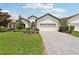 Charming single-story home featuring a manicured lawn, brick driveway, and attached two-car garage at 9307 San Jose Blvd, Howey In The Hills, FL 34737