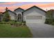 Charming single-story home featuring a manicured lawn, brick driveway, and attached two-car garage at 9307 San Jose Blvd, Howey In The Hills, FL 34737