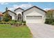 Charming single-story home featuring a manicured lawn, brick driveway, and attached two-car garage at 9307 San Jose Blvd, Howey In The Hills, FL 34737