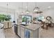Open-concept kitchen with a granite island, pendant lighting, and seamless flow into the living and dining areas at 9307 San Jose Blvd, Howey In The Hills, FL 34737