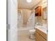 Neutral bathroom featuring a shower-tub combo with a cream-colored shower curtain at 997 Nash Loop, The Villages, FL 32162