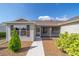Home exterior with a screen door entry, brown shutters, and well maintained landscaping at 997 Nash Loop, The Villages, FL 32162