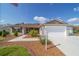 Inviting home with tan siding, manicured lawn, two-car garage, and mature landscaping at 997 Nash Loop, The Villages, FL 32162