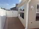 Exterior view of the house featuring white vinyl fencing, beige siding, and outdoor lighting at 997 Nash Loop, The Villages, FL 32162